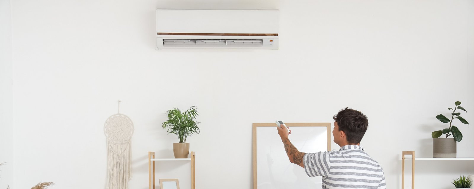 Ein Mann stellt eine Klima-Splitanlage ein