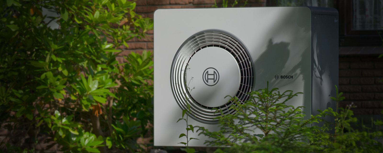 eine Wärmepumpe, die an einer Hauswand steht