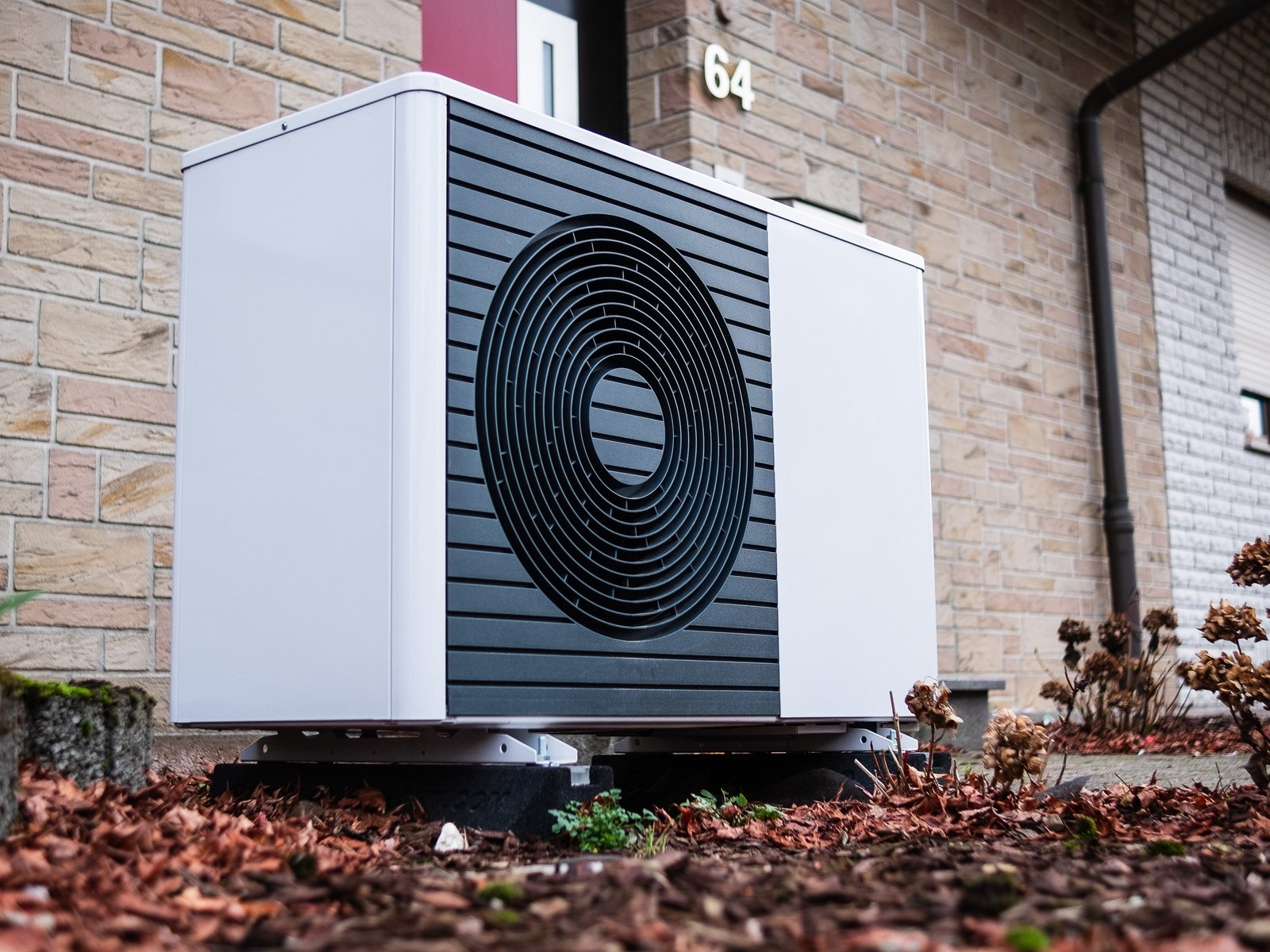 eine Wärmepumpe, die an einer Hauswand steht